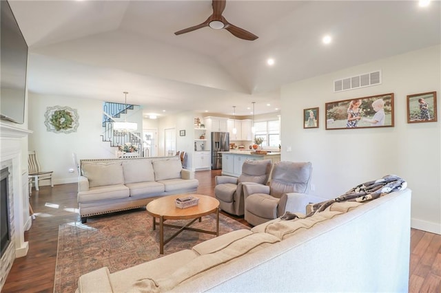 living room with lofted ceiling, dark hardwood / wood-style floors, and ceiling fan