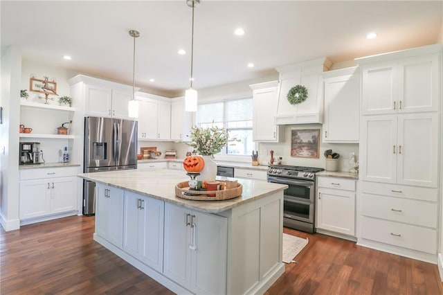 kitchen featuring hanging light fixtures, a kitchen island, appliances with stainless steel finishes, white cabinetry, and dark wood-type flooring