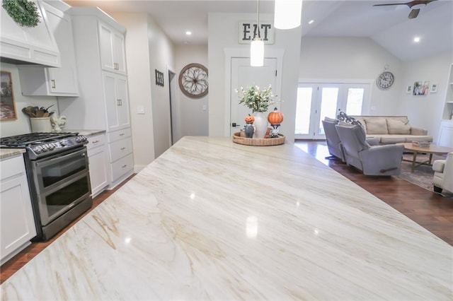 kitchen featuring premium range hood, white cabinetry, vaulted ceiling, black range with gas cooktop, and light stone counters