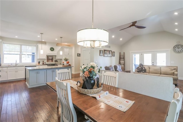 dining area with lofted ceiling, dark wood-type flooring, ceiling fan with notable chandelier, french doors, and sink