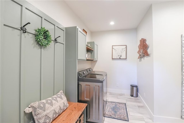 washroom with washing machine and clothes dryer and cabinets