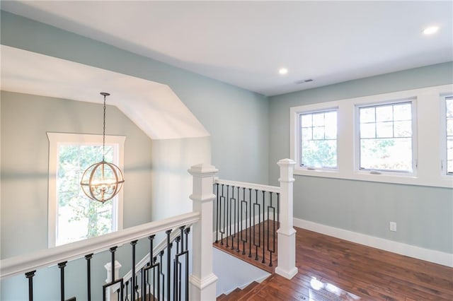 corridor with a notable chandelier and dark hardwood / wood-style floors