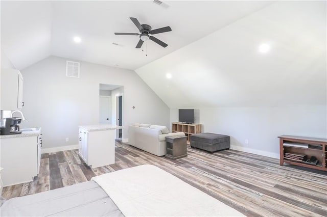 bedroom featuring sink, wood-type flooring, vaulted ceiling, and ceiling fan