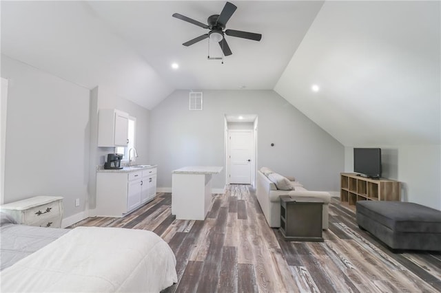 bedroom featuring ceiling fan, sink, dark wood-type flooring, and vaulted ceiling