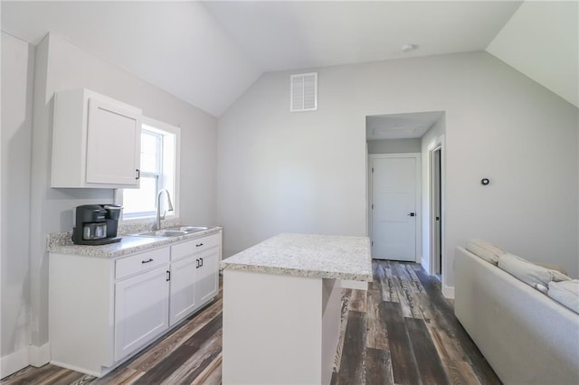 kitchen with a kitchen island, dark wood-type flooring, sink, vaulted ceiling, and white cabinetry