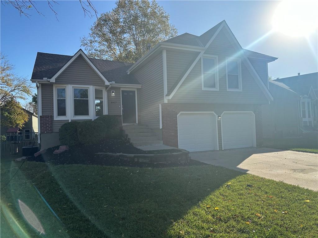 tri-level home with a front lawn and a garage