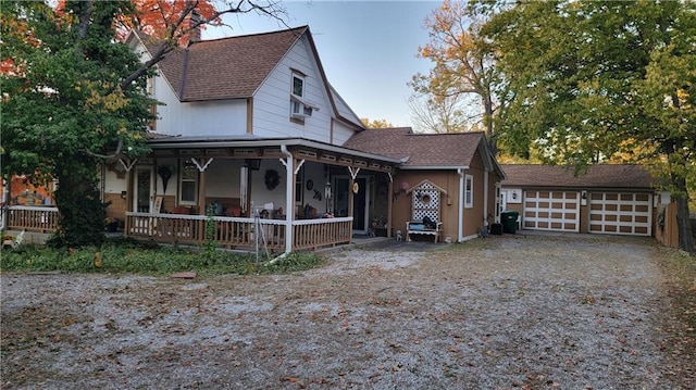 view of front of property featuring a porch, an outbuilding, and a garage