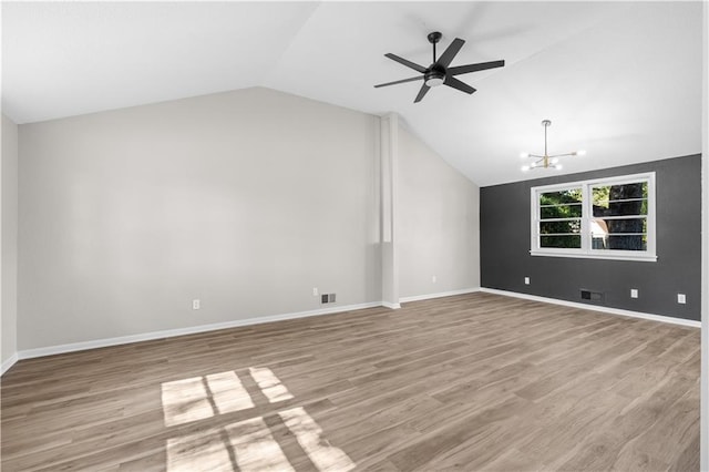 unfurnished living room with vaulted ceiling, light hardwood / wood-style flooring, and ceiling fan with notable chandelier