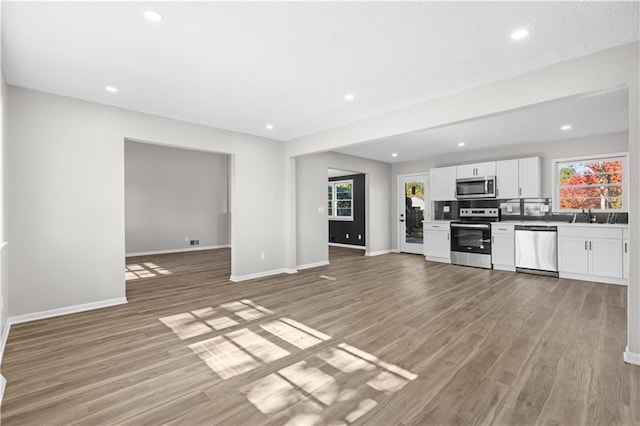 kitchen featuring white cabinetry, stainless steel appliances, and light wood-type flooring