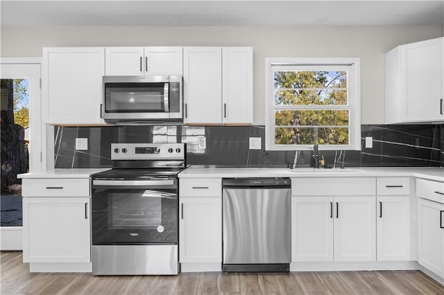 kitchen featuring white cabinetry, appliances with stainless steel finishes, and light hardwood / wood-style flooring