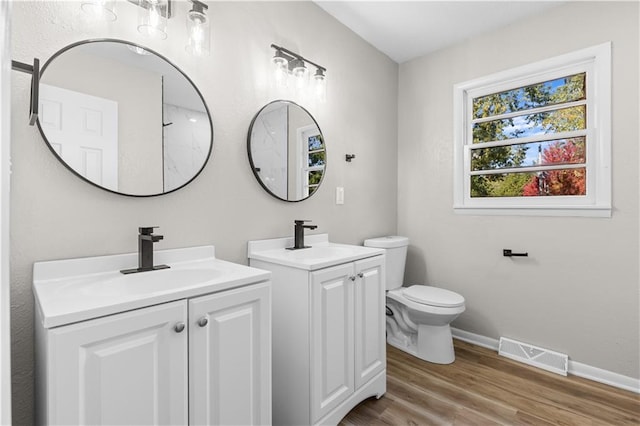 bathroom with toilet, hardwood / wood-style floors, and vanity