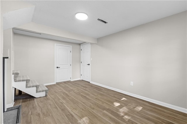 basement with a textured ceiling and wood-type flooring