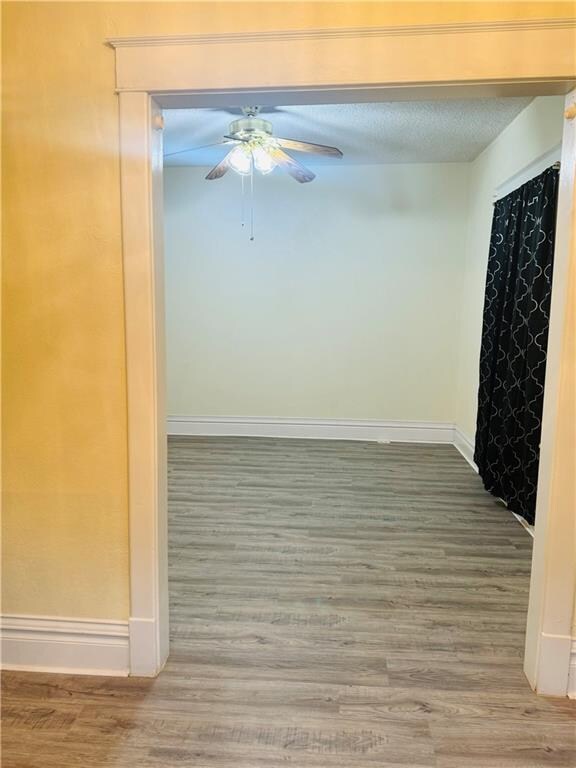 corridor featuring a textured ceiling and hardwood / wood-style flooring