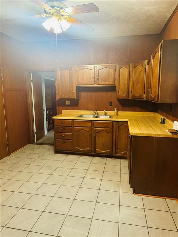 kitchen featuring light tile patterned flooring, sink, and ceiling fan