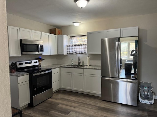 kitchen with appliances with stainless steel finishes, white cabinets, and plenty of natural light