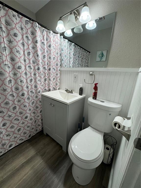 bathroom featuring vanity, hardwood / wood-style floors, toilet, and walk in shower