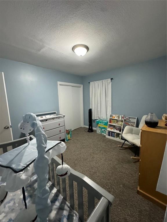 carpeted bedroom featuring a textured ceiling