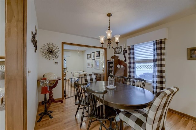 dining area featuring light hardwood / wood-style flooring and an inviting chandelier