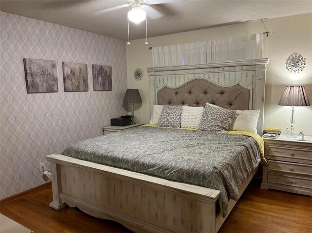 320 Jones Ave, Warrensburg, MO 64093 - bedroom with wallpapered walls, wood finished floors, a ceiling fan, and baseboards