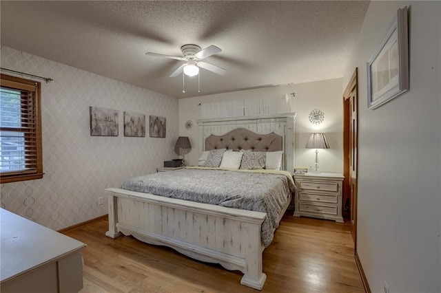 bedroom with light hardwood / wood-style floors, a textured ceiling, and ceiling fan