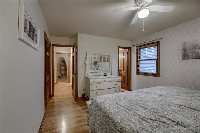 320 Jones Ave, Warrensburg, MO 64093 - bedroom featuring wood finished floors, wallpapered walls, baseboards, and a ceiling fan