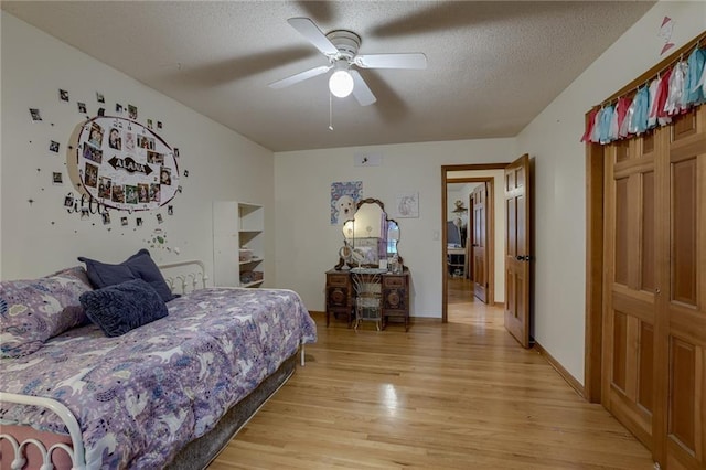 bedroom with ceiling fan, a textured ceiling, and light hardwood / wood-style flooring