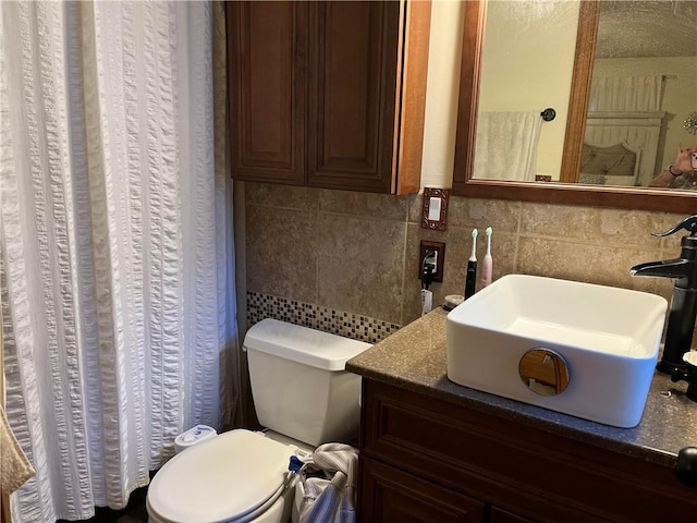 bathroom with backsplash, vanity, curtained shower, and toilet