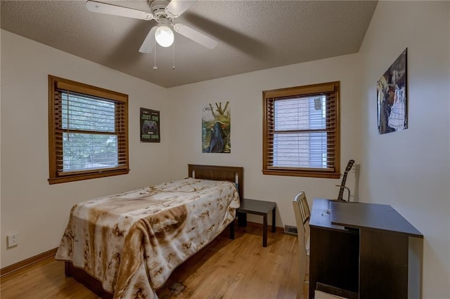 bedroom featuring ceiling fan, a textured ceiling, and light hardwood / wood-style flooring