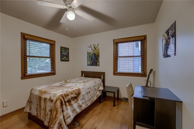 320 Jones Ave, Warrensburg, MO 64093 - bedroom featuring light wood-style flooring, baseboards, ceiling fan, and a textured ceiling