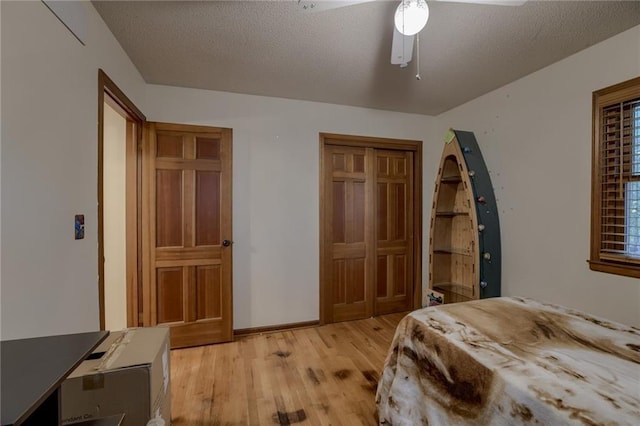 bedroom featuring ceiling fan, a textured ceiling, and light wood-type flooring