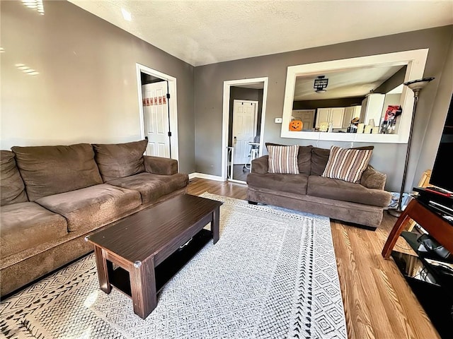 living room featuring a textured ceiling and light hardwood / wood-style floors