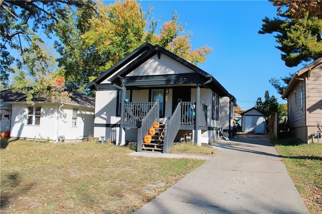 bungalow featuring a storage shed, a front lawn, and a porch