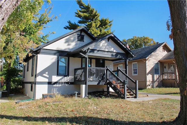 bungalow-style house with a front lawn and covered porch