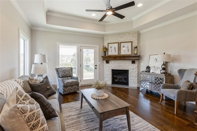 living room featuring crown molding, a fireplace, and dark hardwood / wood-style flooring