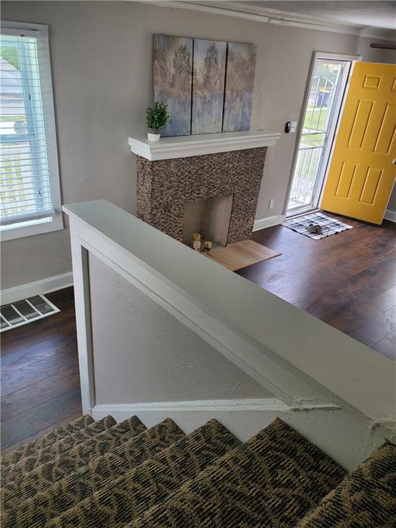 entryway with a high end fireplace and dark wood-type flooring