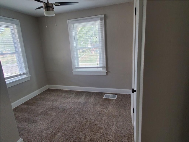 empty room featuring ceiling fan, a healthy amount of sunlight, and carpet