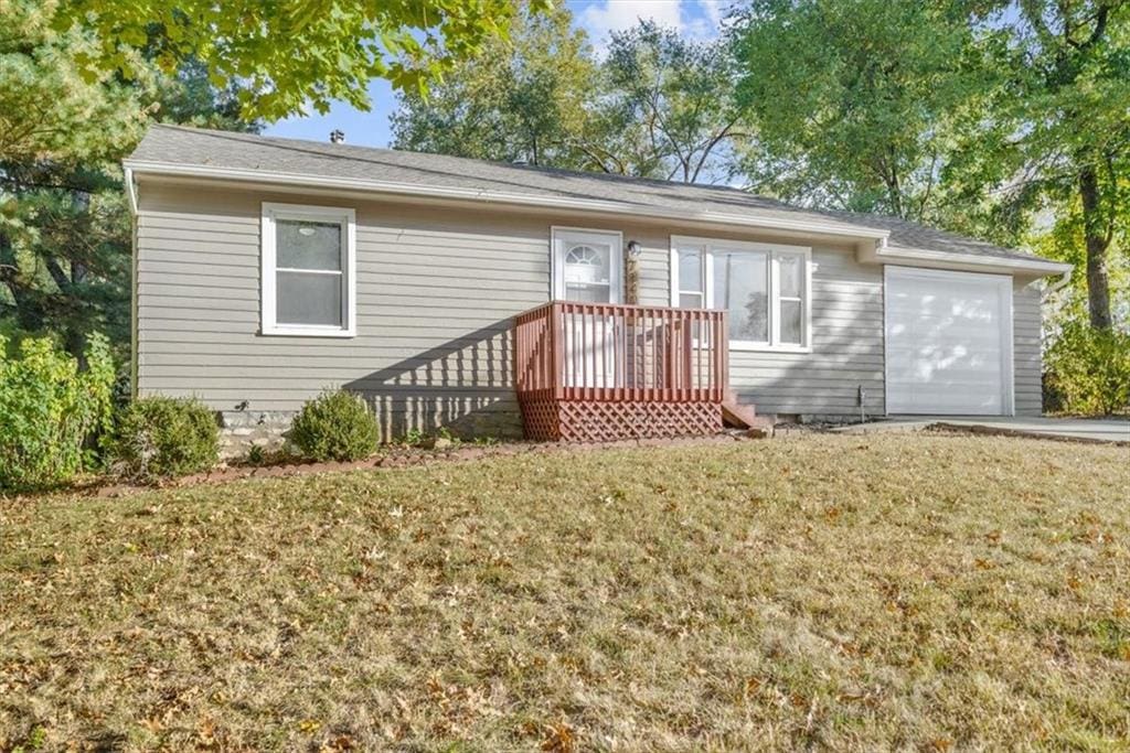 view of front of property with a front lawn, a wooden deck, and a garage