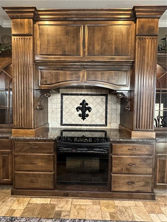 kitchen featuring electric range, crown molding, dark stone counters, and custom range hood