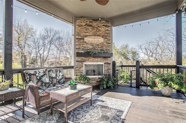 wooden deck with an outdoor living space with a fireplace and ceiling fan