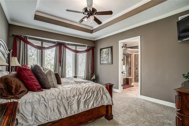 bedroom featuring connected bathroom, ceiling fan, a raised ceiling, crown molding, and light carpet