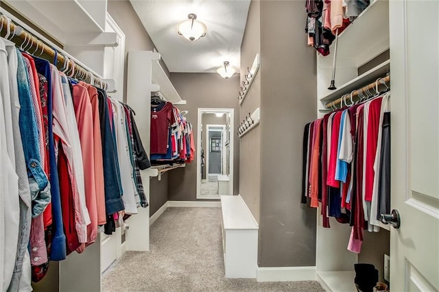 walk in closet featuring light colored carpet