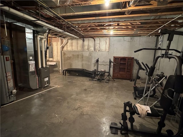 basement featuring electric panel, gas water heater, and heating unit