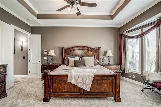 bedroom featuring baseboards, a tray ceiling, ornamental molding, and light colored carpet