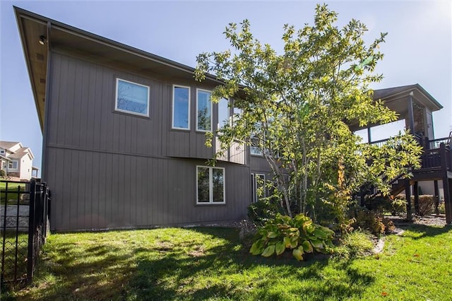 view of home's exterior featuring a lawn and fence