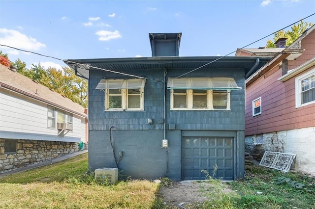 rear view of house with cooling unit and a garage