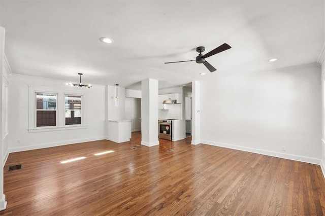 unfurnished living room featuring ornamental molding, hardwood / wood-style flooring, and ceiling fan with notable chandelier