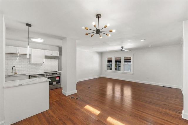 kitchen featuring dark hardwood / wood-style floors, stainless steel appliances, sink, light stone countertops, and white cabinetry