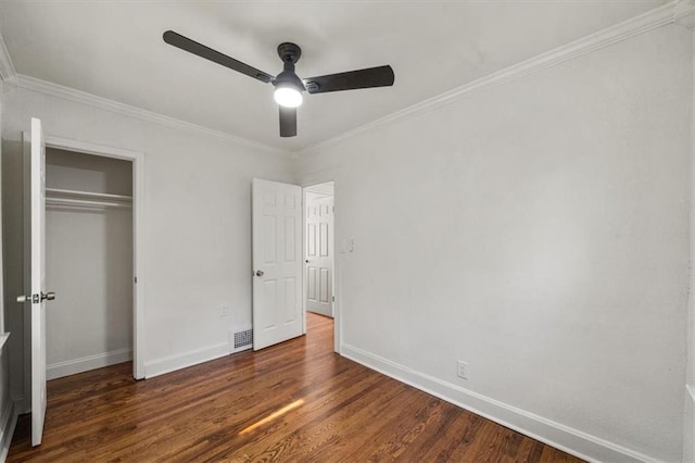 unfurnished bedroom with dark hardwood / wood-style flooring, crown molding, a closet, and ceiling fan