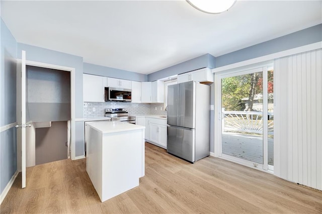 kitchen featuring white cabinetry, light hardwood / wood-style flooring, appliances with stainless steel finishes, and a center island