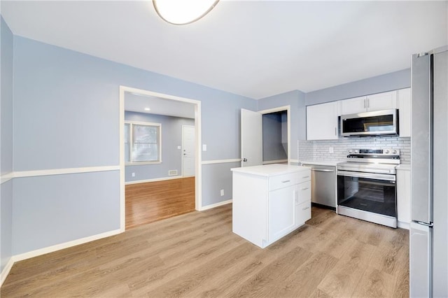 kitchen featuring a kitchen island, light wood-type flooring, white cabinets, and stainless steel appliances